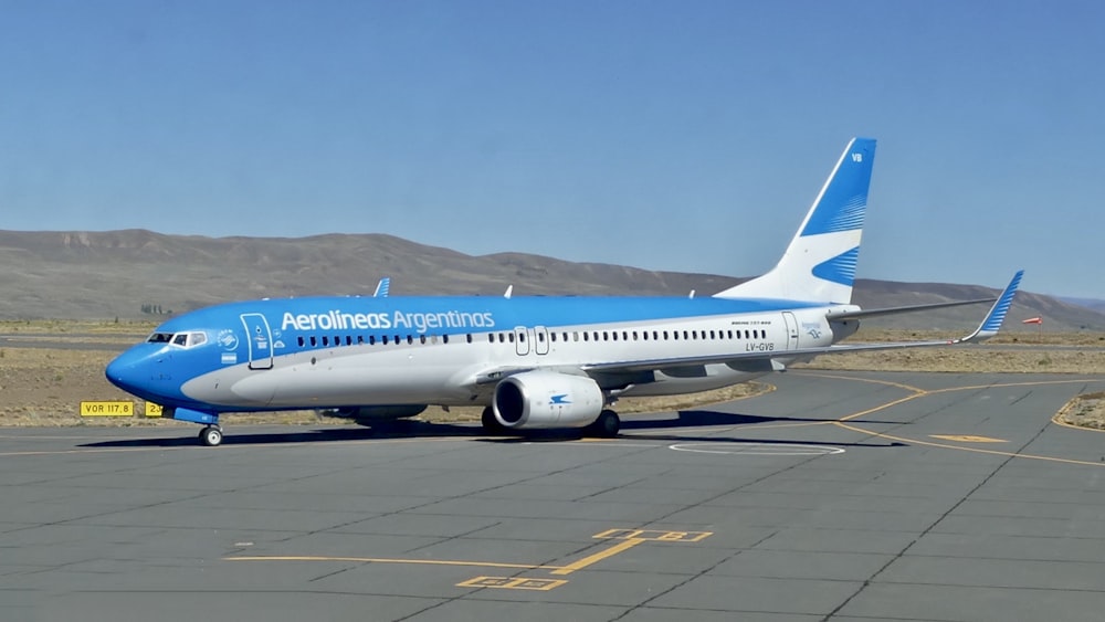 a blue and white airplane is on the runway