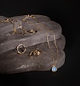 a couple of rings and a necklace on a rock