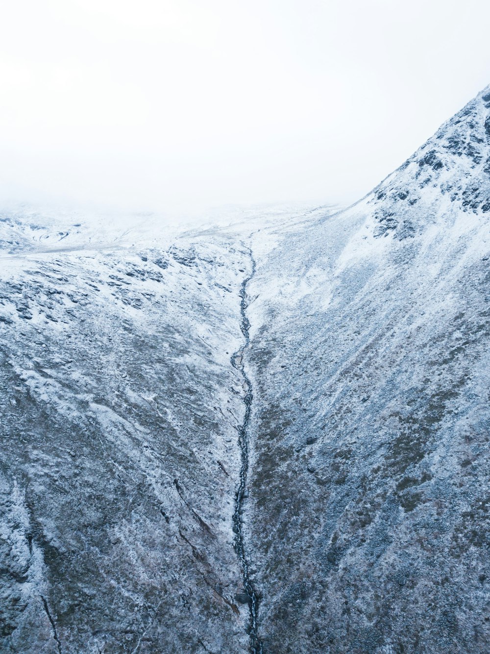 a snow covered mountain with a crack in the side