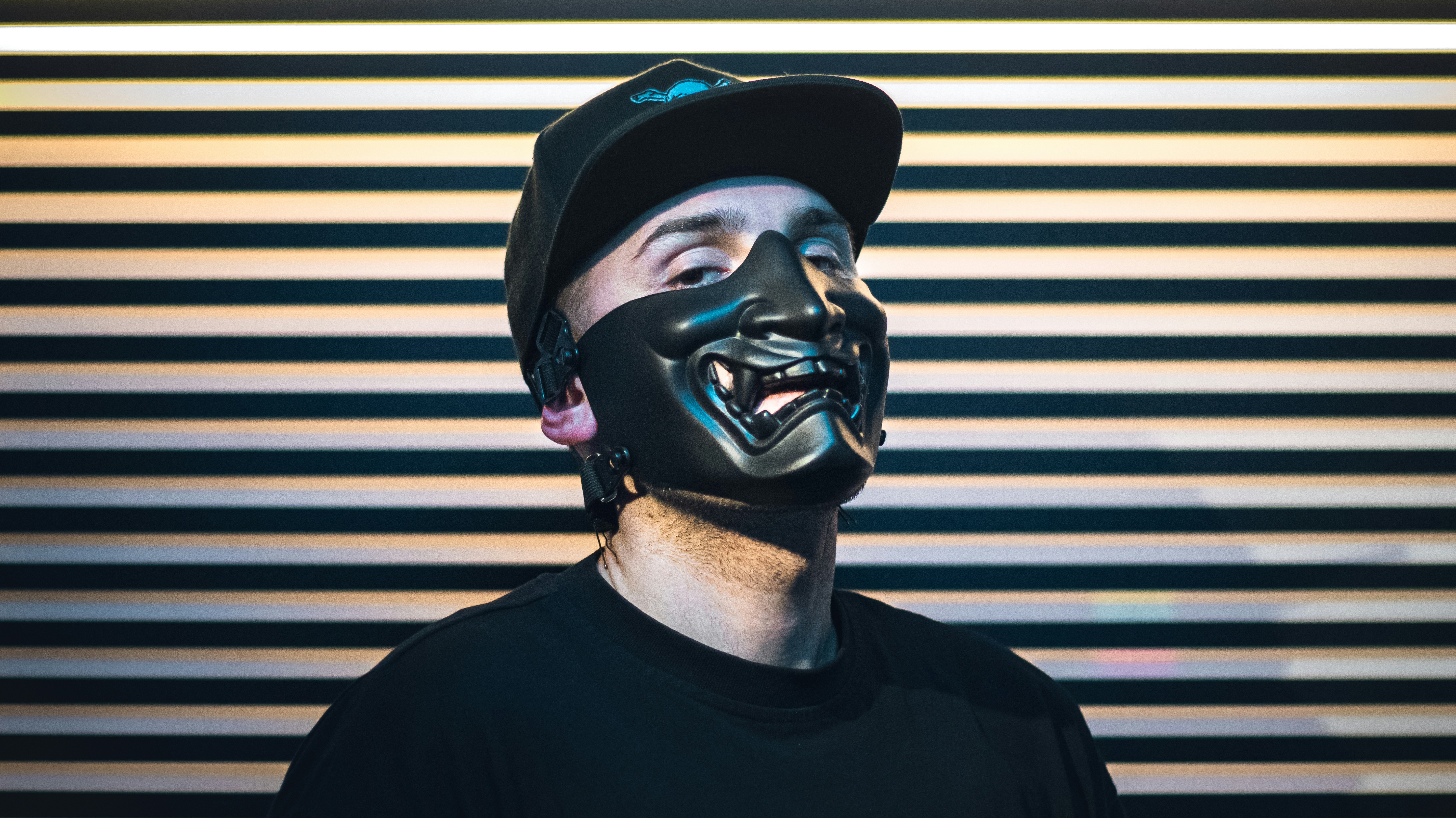 Un uomo che indossa una maschera nera e un cappello nero