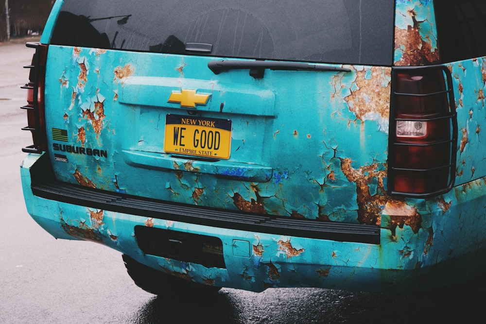 the back of a blue truck with rust on it