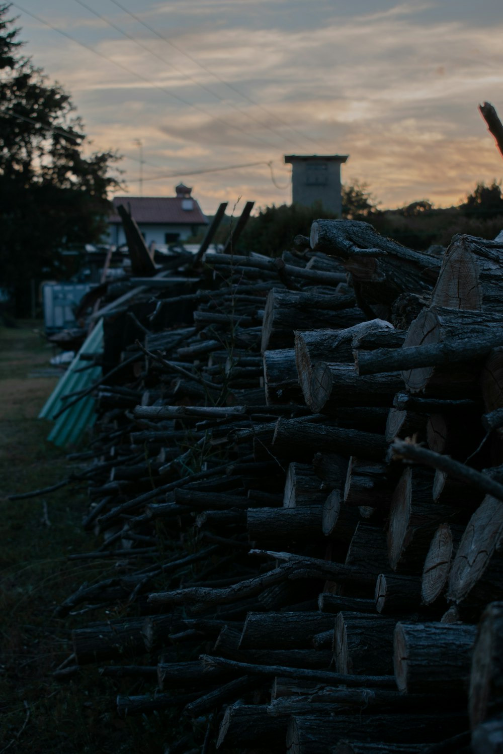 a pile of logs sitting next to a house