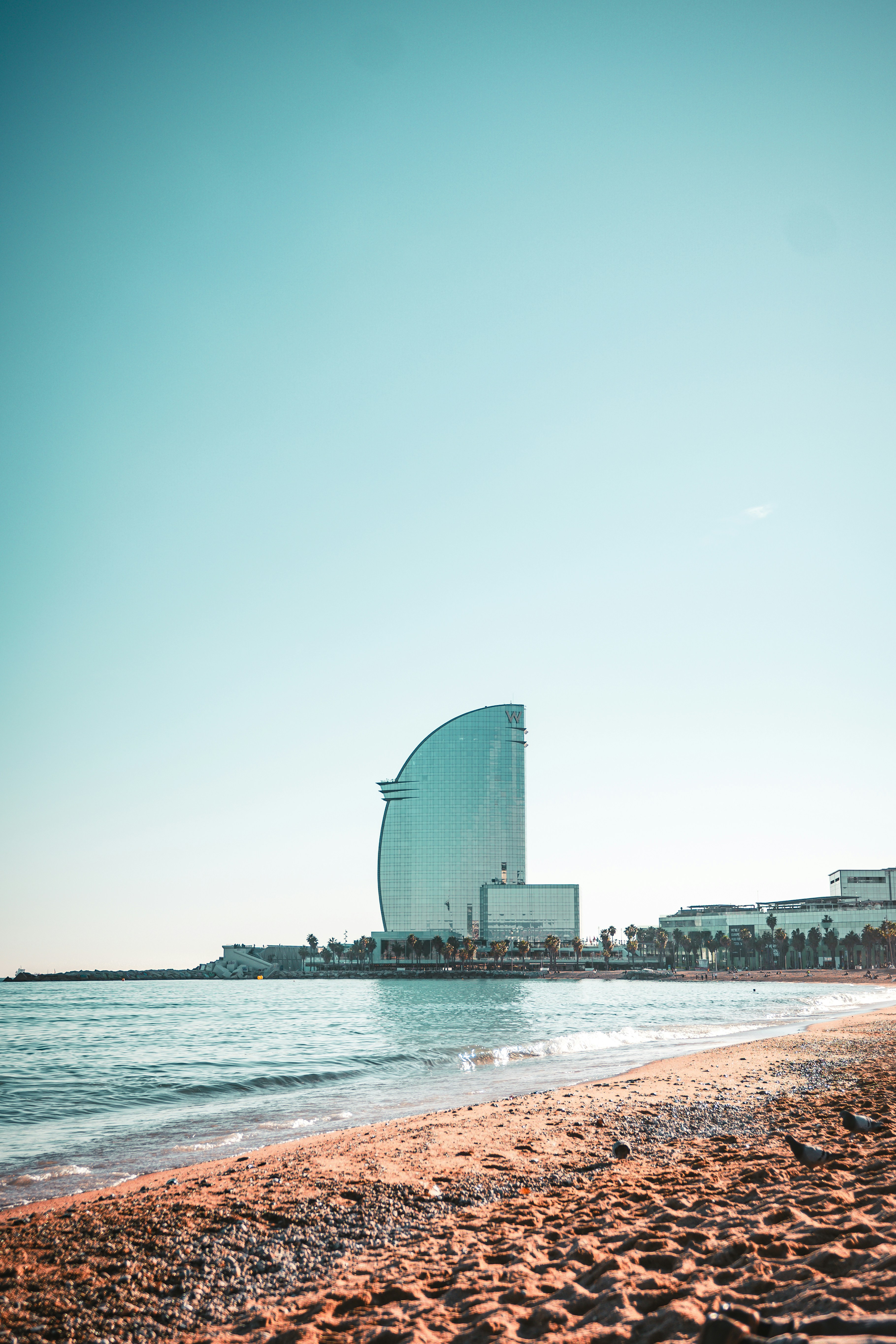 a large building sitting on top of a beach next to the ocean