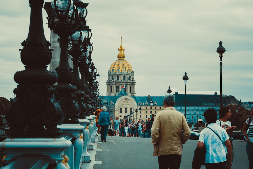 a group of people walking across a bridge