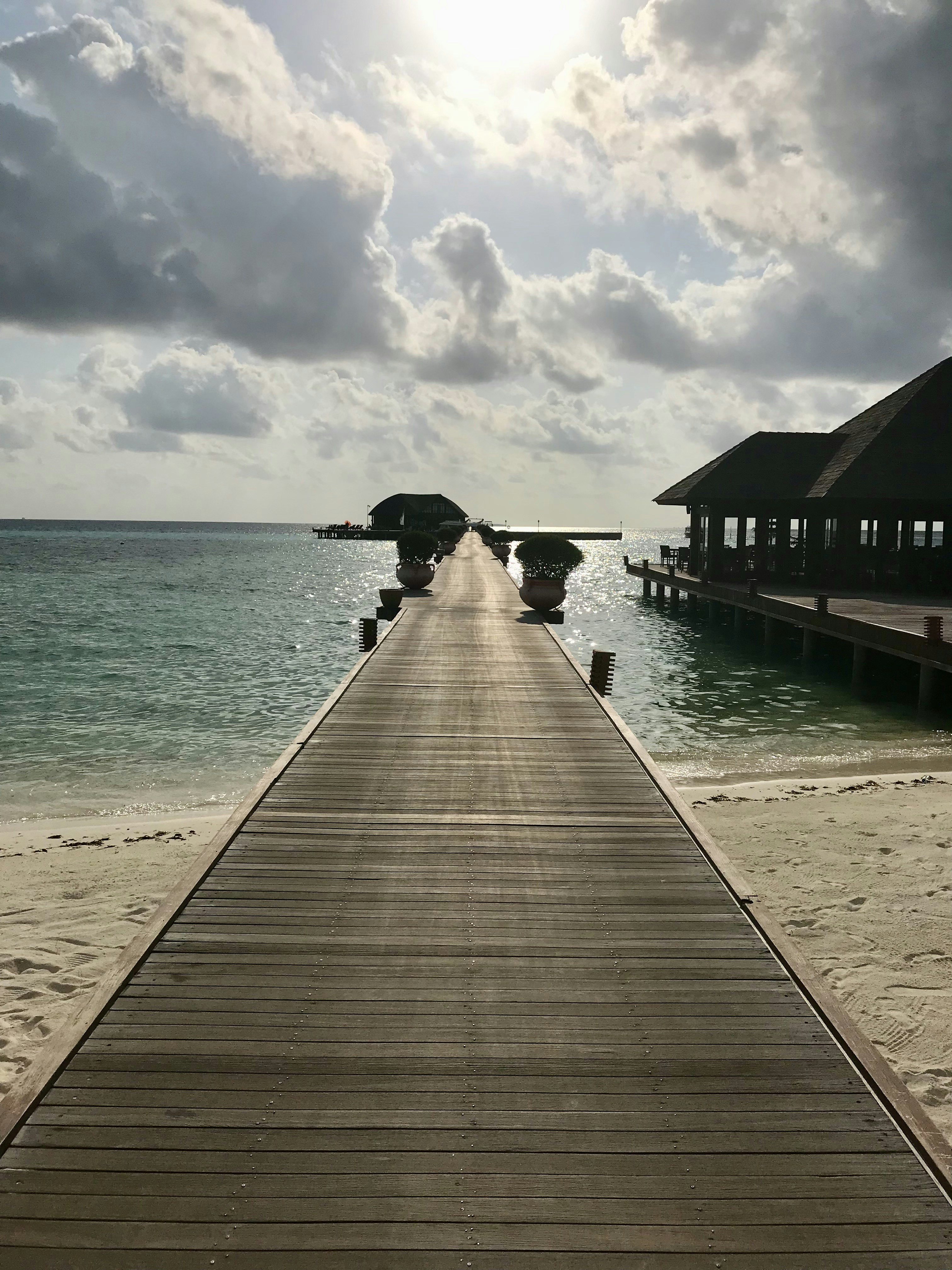 a long wooden pier extending into the ocean
