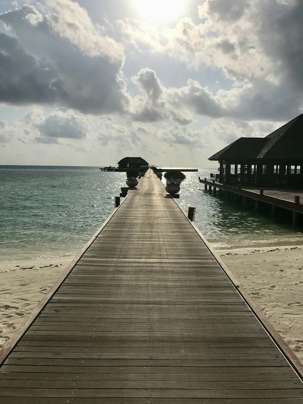 a long wooden pier extending into the ocean