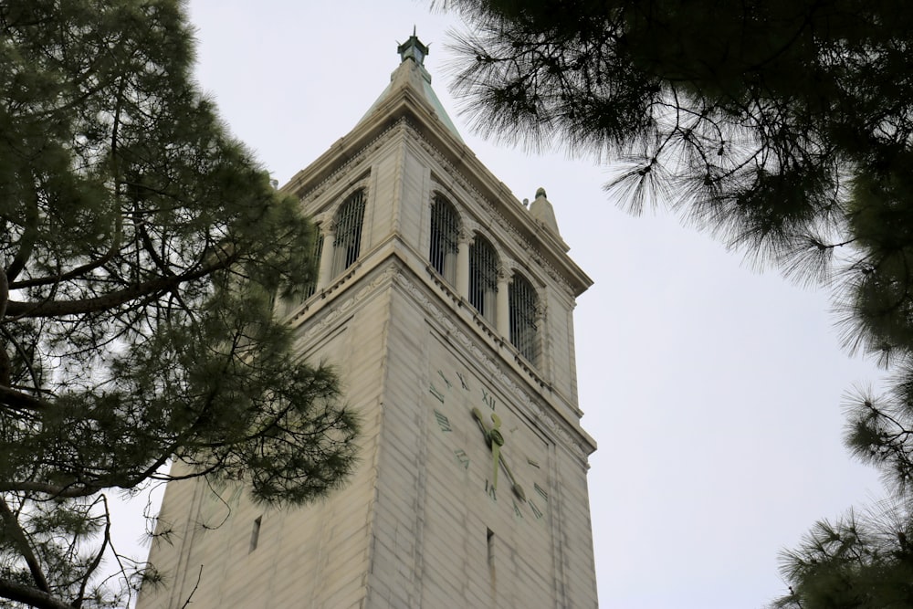 a tall white tower with a clock on it's side