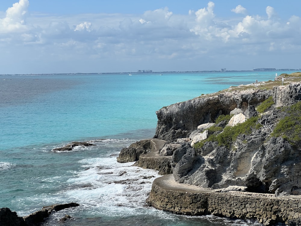 a large body of water next to a rocky shore