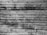 Close-up of a textured wooden surface with parallel lines and patches of dark, grainy dirt or mold.