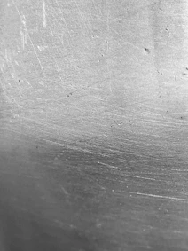 a black and white photo of a metal surface