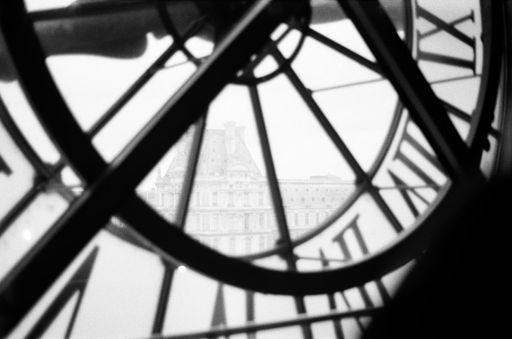 a close up of a clock face with a building in the background