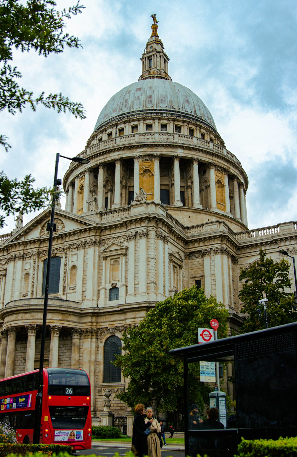 a red double decker bus parked in front of a building