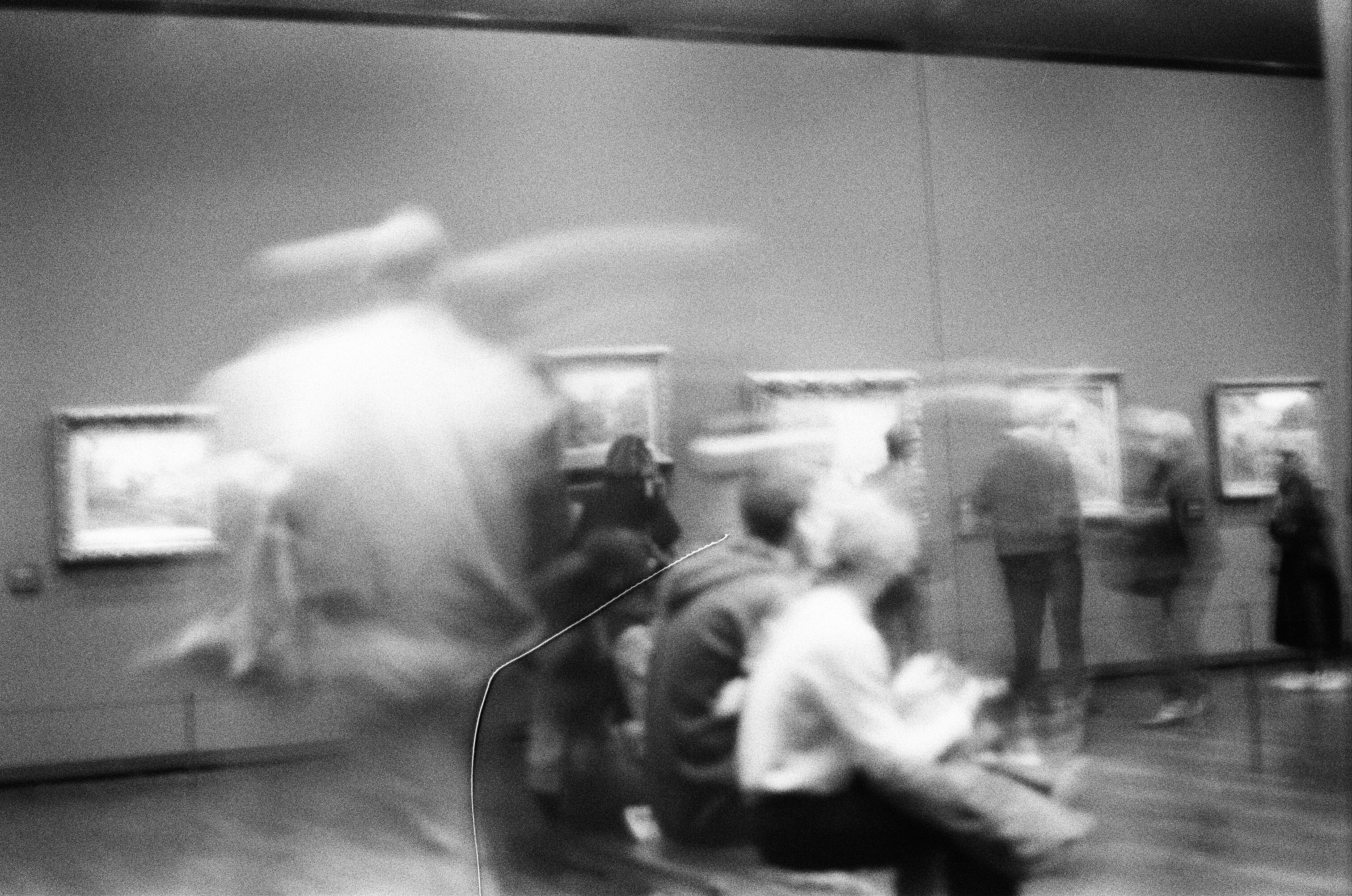 a blurry photo of people in an art gallery