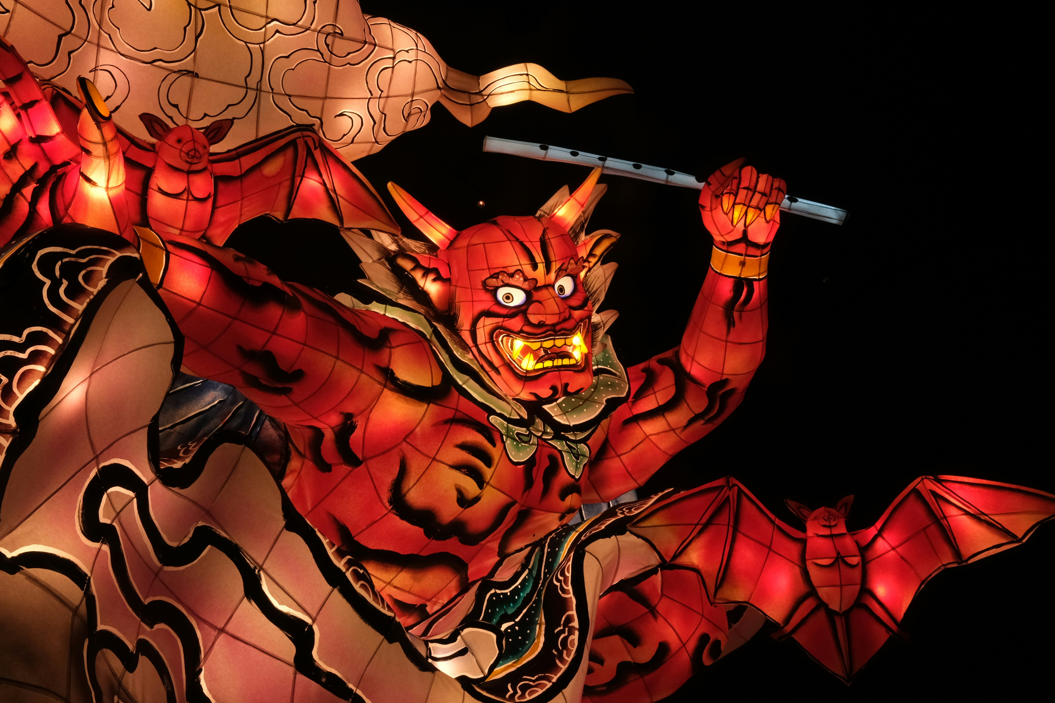 a red dragon statue with a sword in its hand