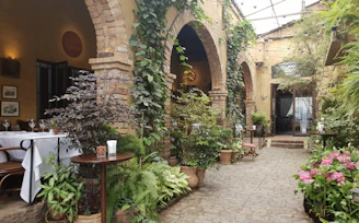 Outdoor garden terrace with vibrant flowers and intimate dining tables.