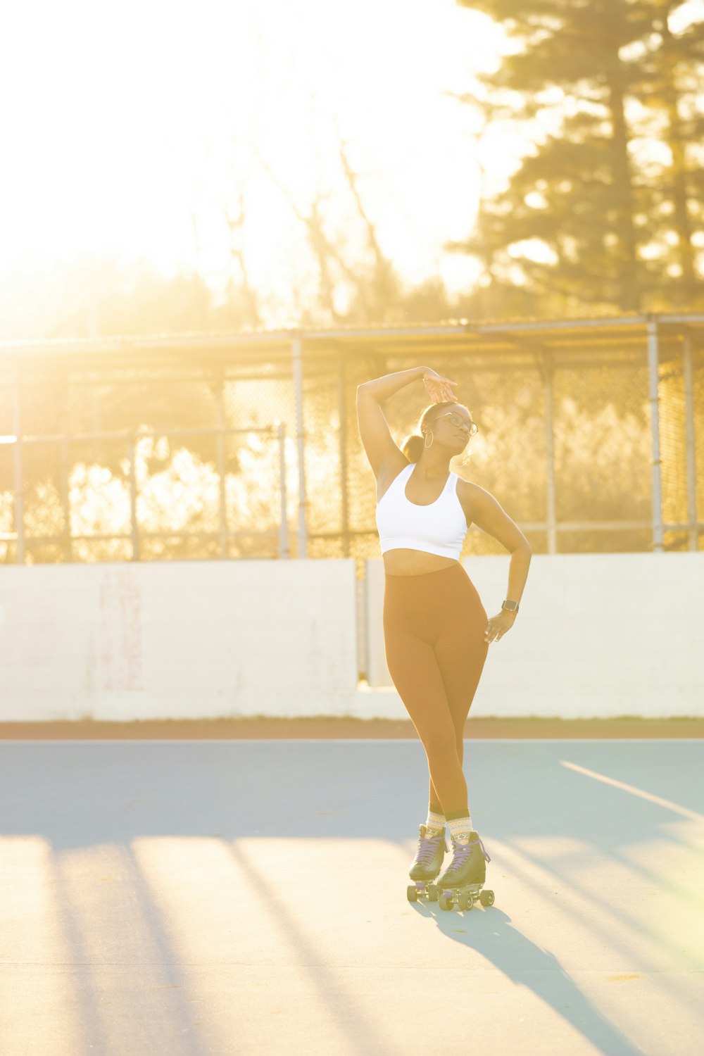 a woman riding a skateboard on top of a tennis court