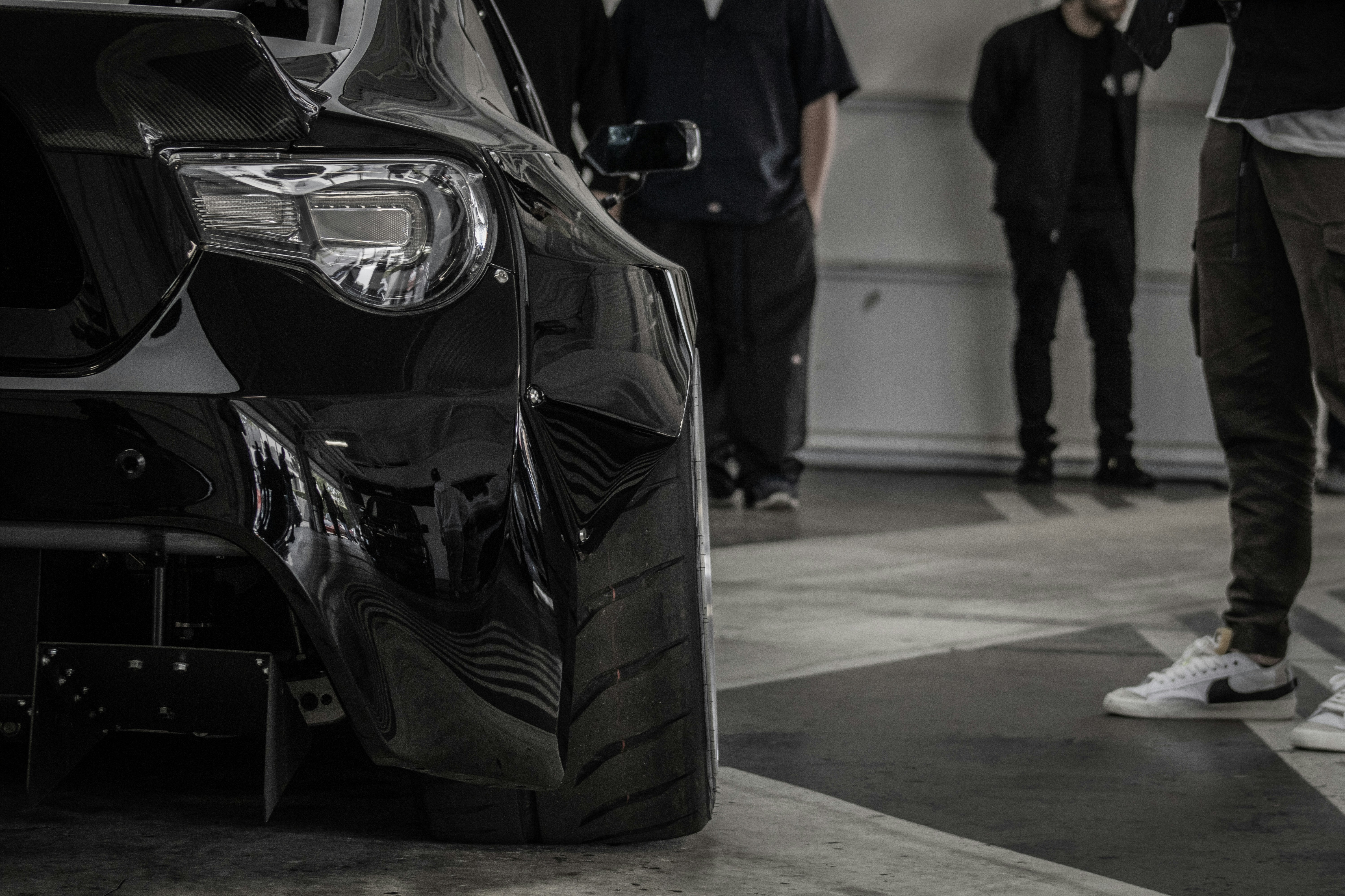 Technicians working on a damaged Tesla in a certified body shop