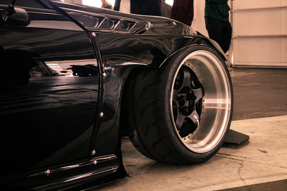 Close-up of a black car's wheel and tyre
