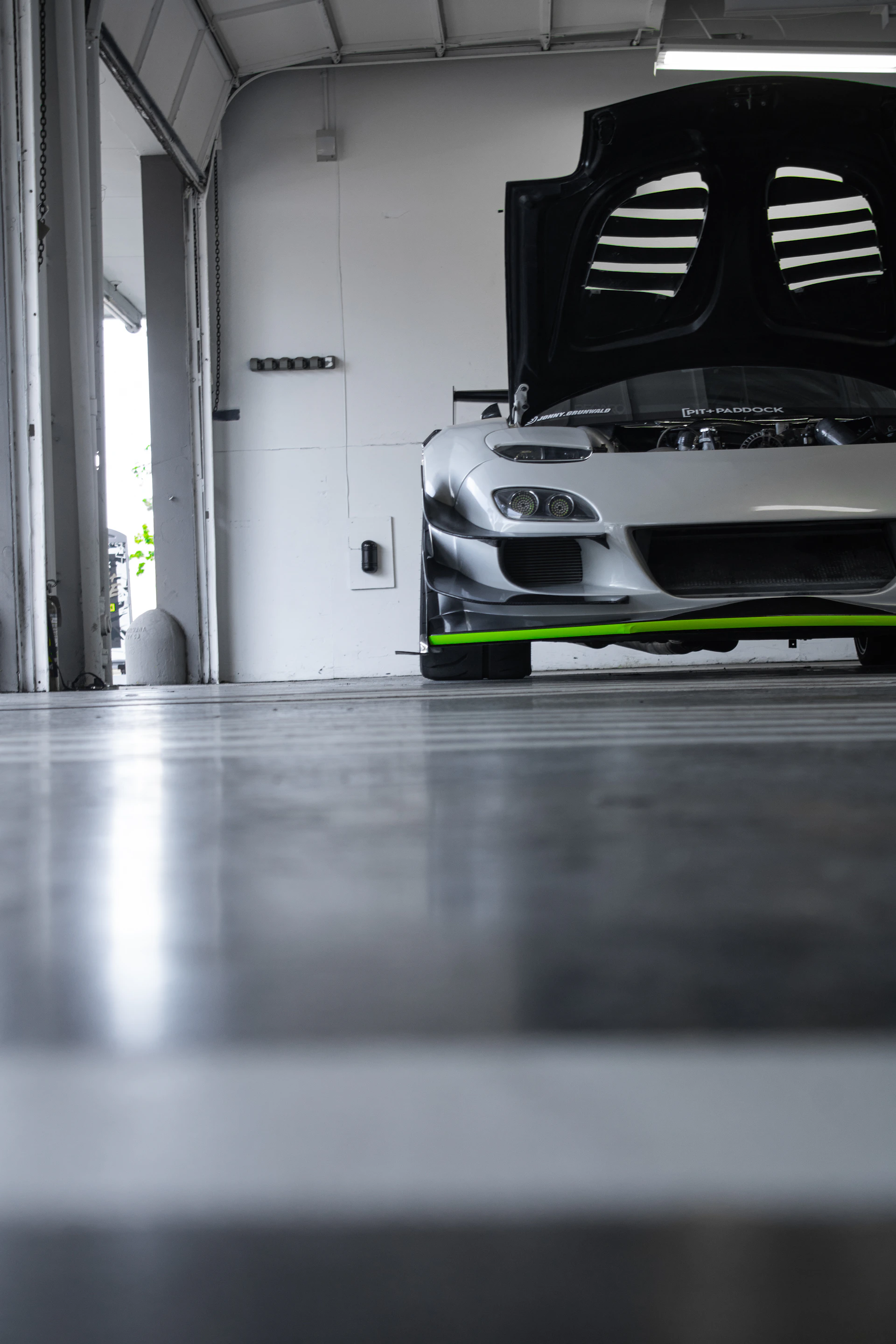 a car parked in a garage with its hood open