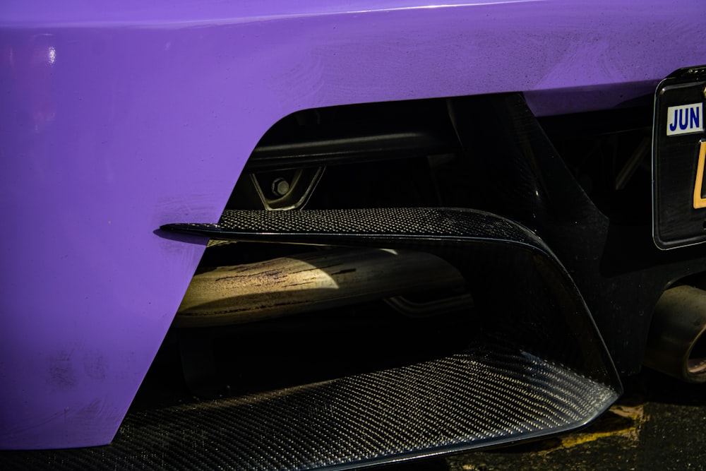a close up of the front bumper of a purple car