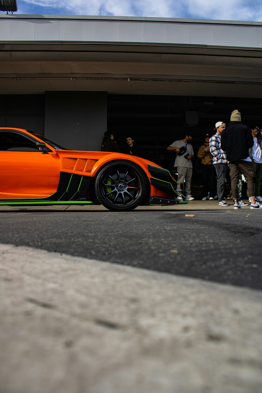 an orange sports car parked in front of a building