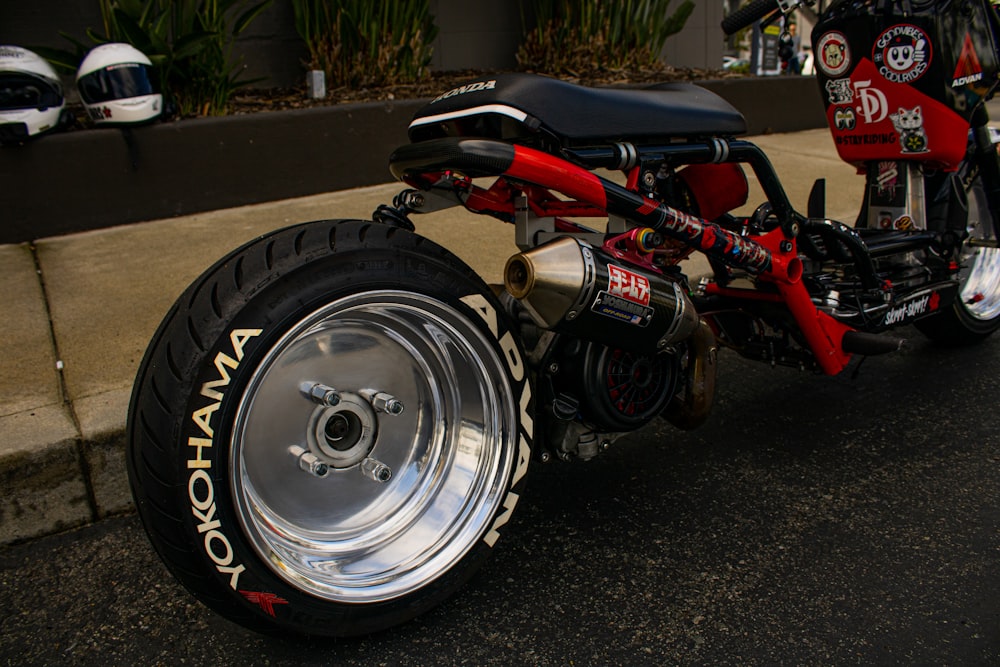 a red and black motorcycle parked on the side of the road