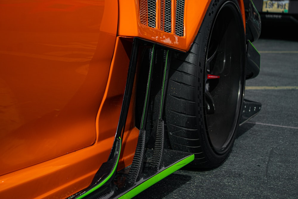 a close up of the front of an orange sports car