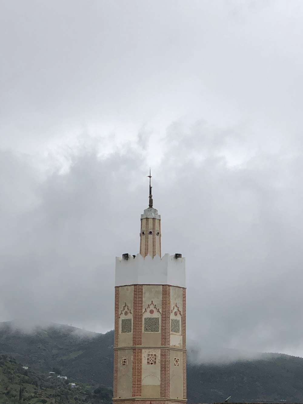 a tall tower with a cross on top of it