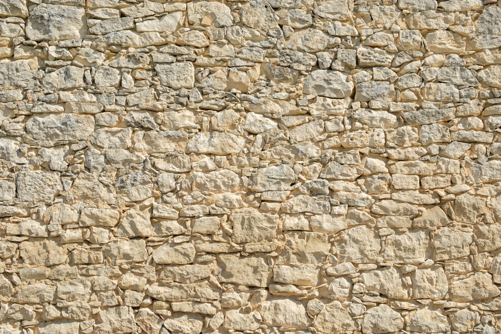 a stone wall with a bench in front of it