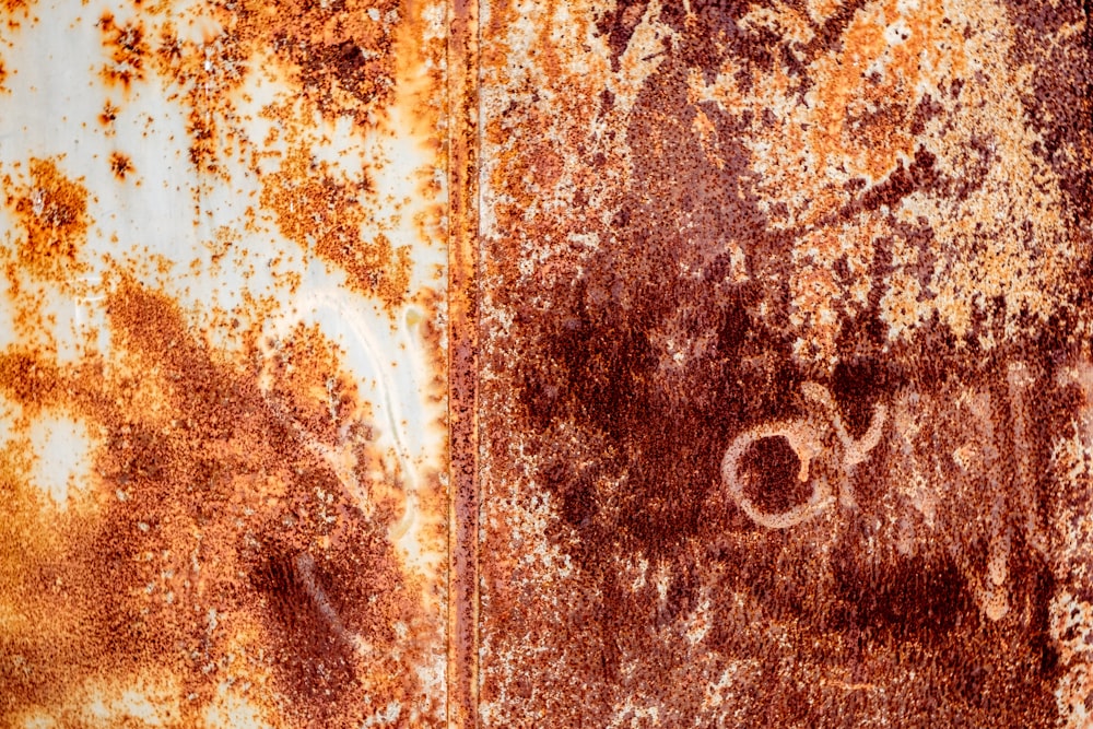a rusted metal surface with some writing on it