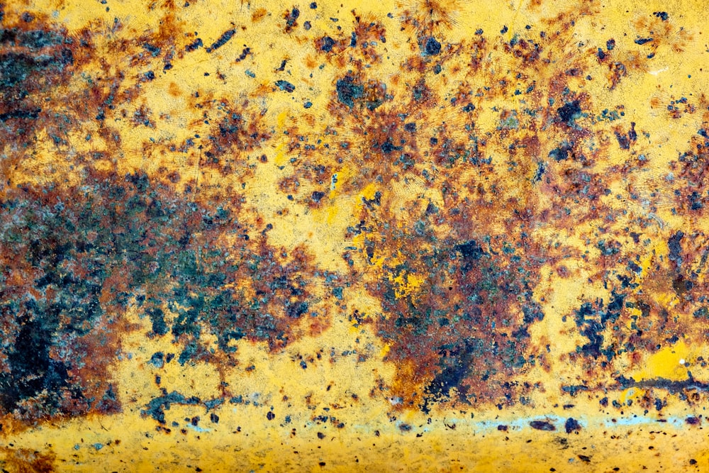 a rusted metal surface with a yellow background