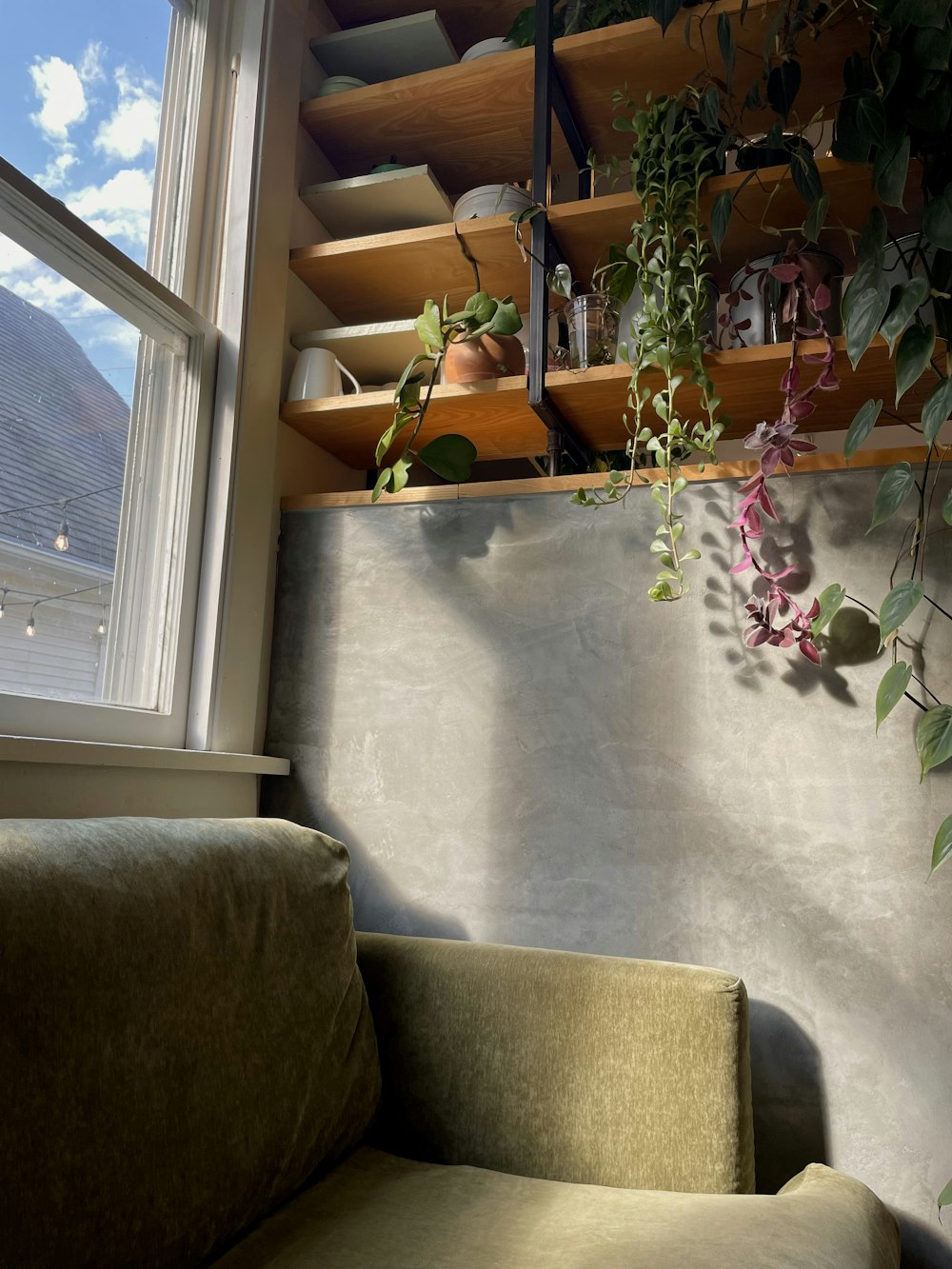 a couch sitting in front of a window next to a window sill