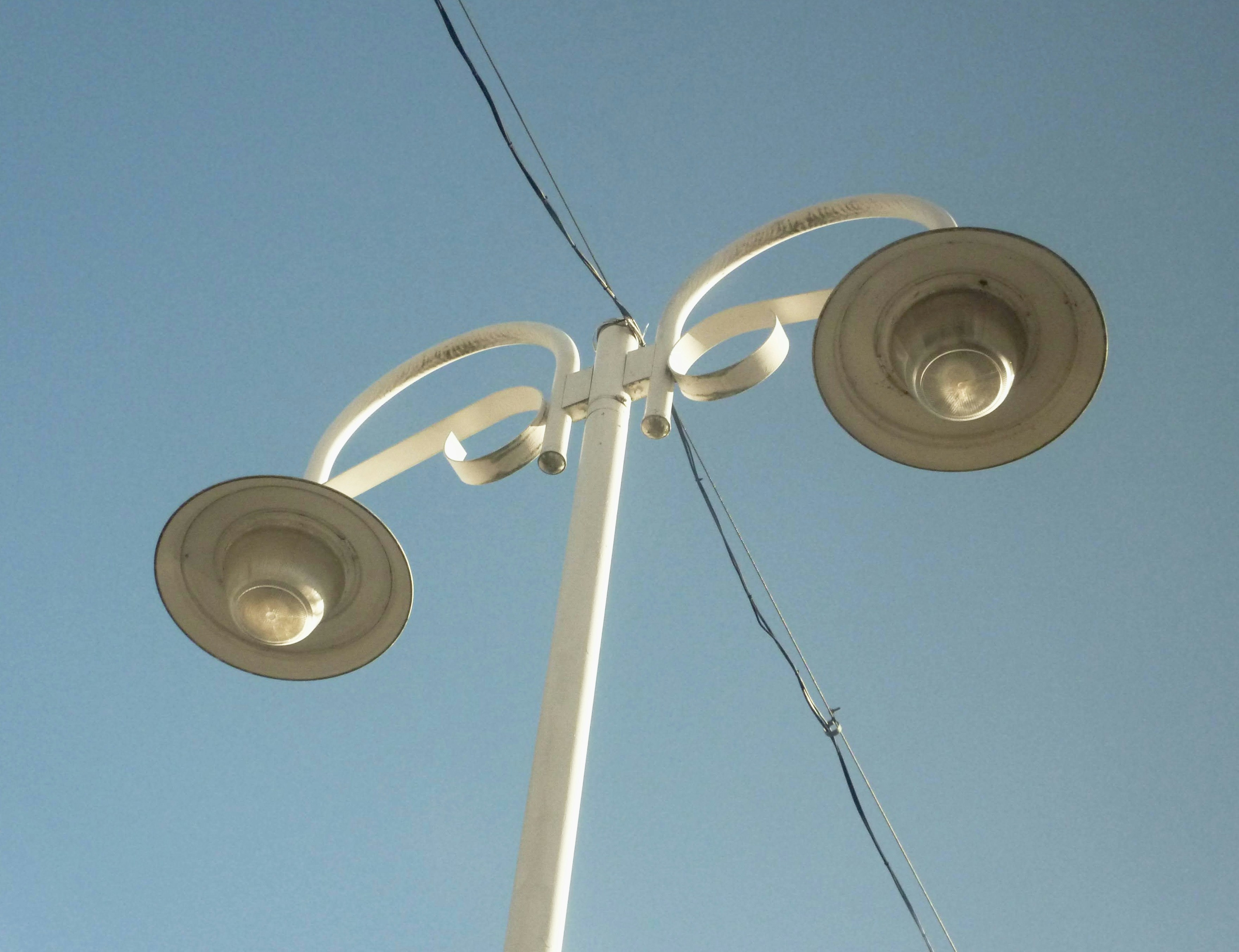 a street light on a pole with a blue sky in the background