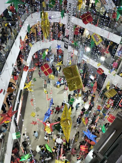 Floating clusters of percentage symbols and gift boxes glowing softly in a photorealistic mall environment.