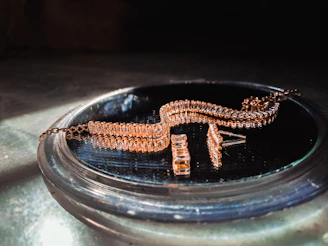 Artisan polishing a gold necklace under warm light, highlighting craftsmanship details.