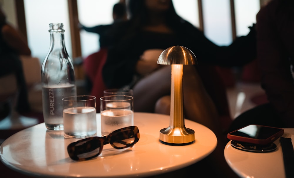 a table topped with glasses and a lamp
