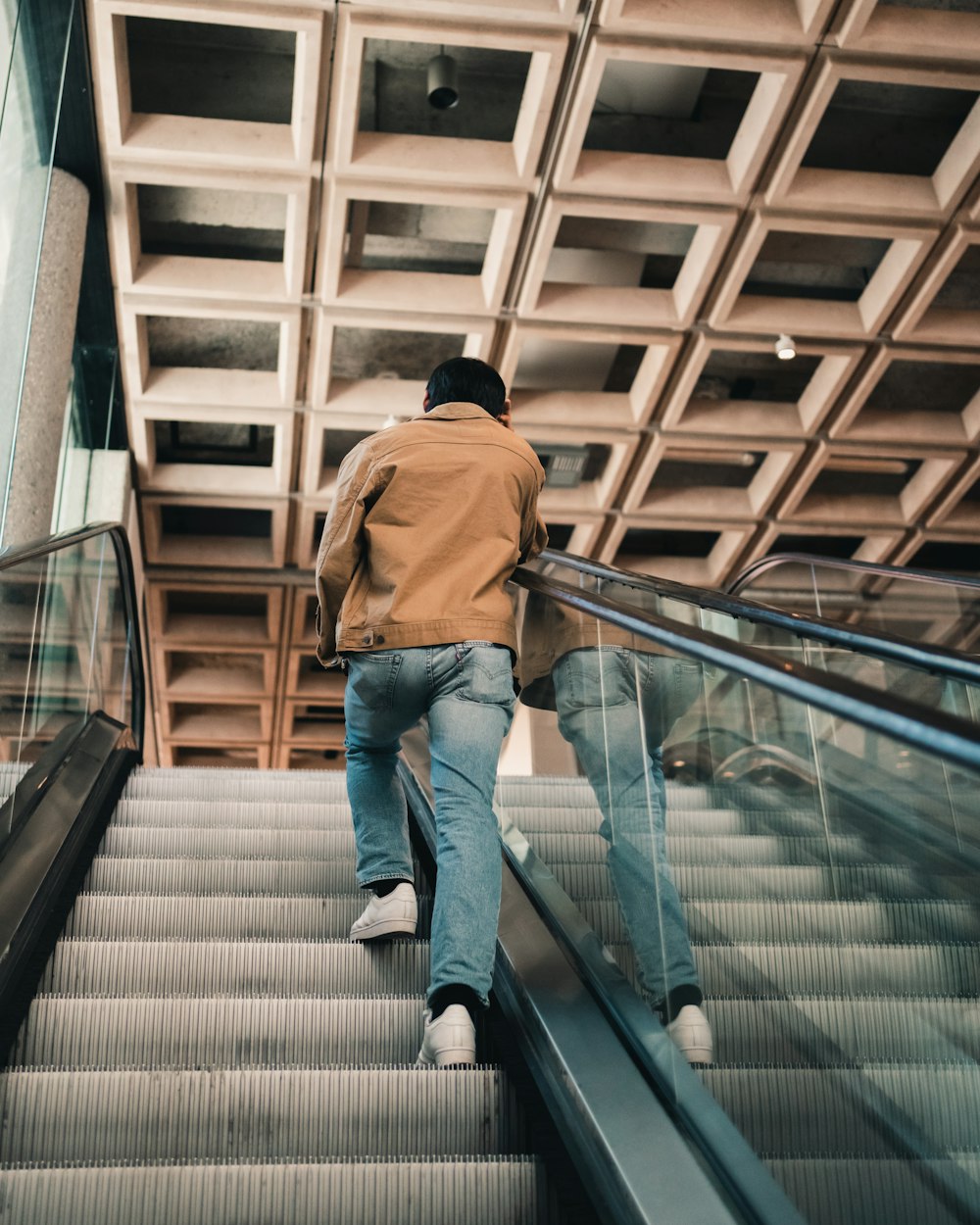 a man walking down an escalator in a building