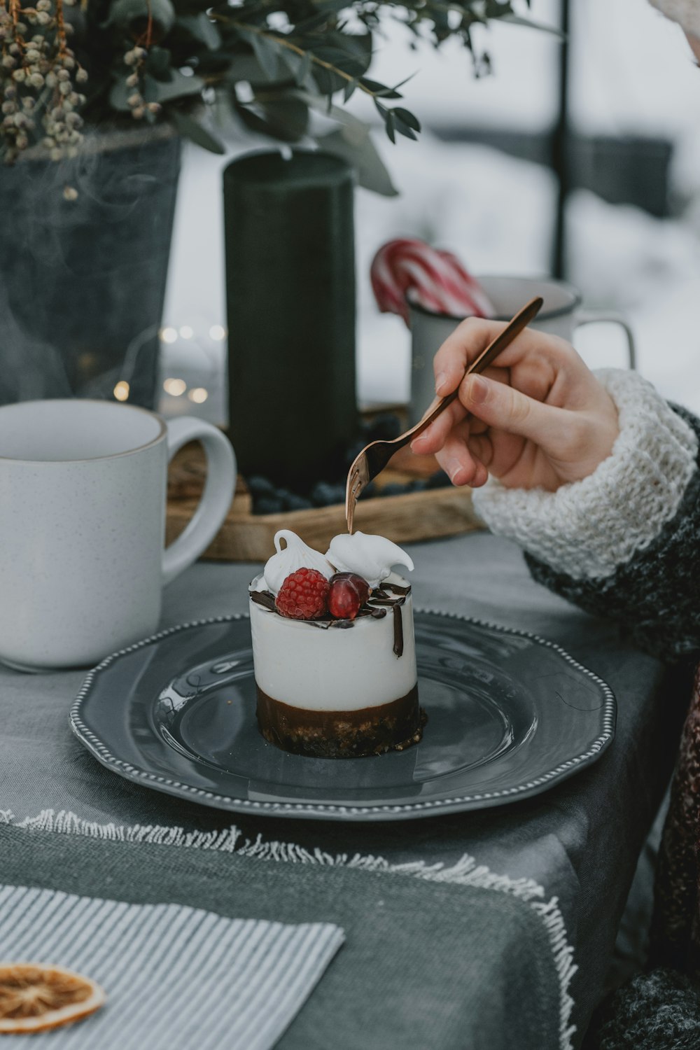 a woman is cutting into a dessert on a plate