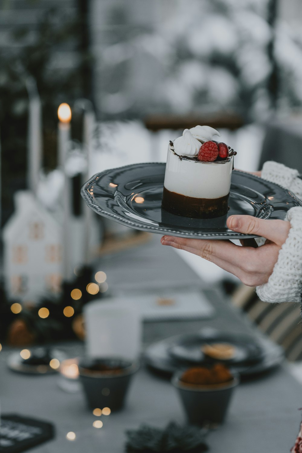 a person holding a plate with a dessert on it