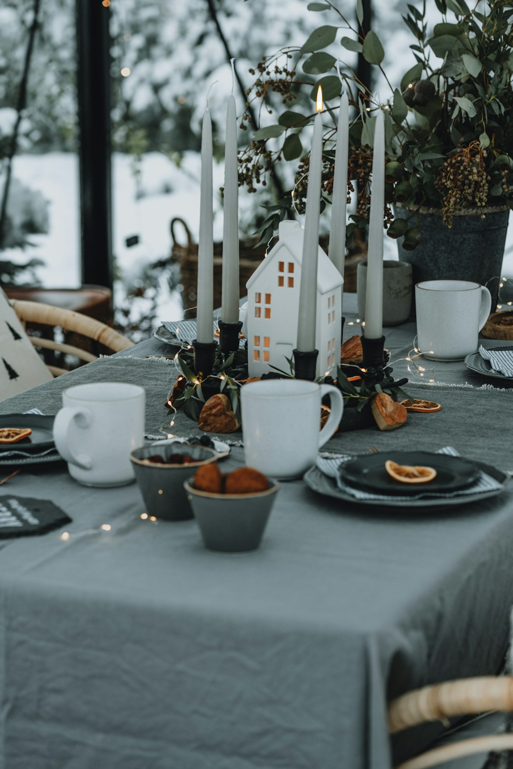 a table set with plates, cups, and candles