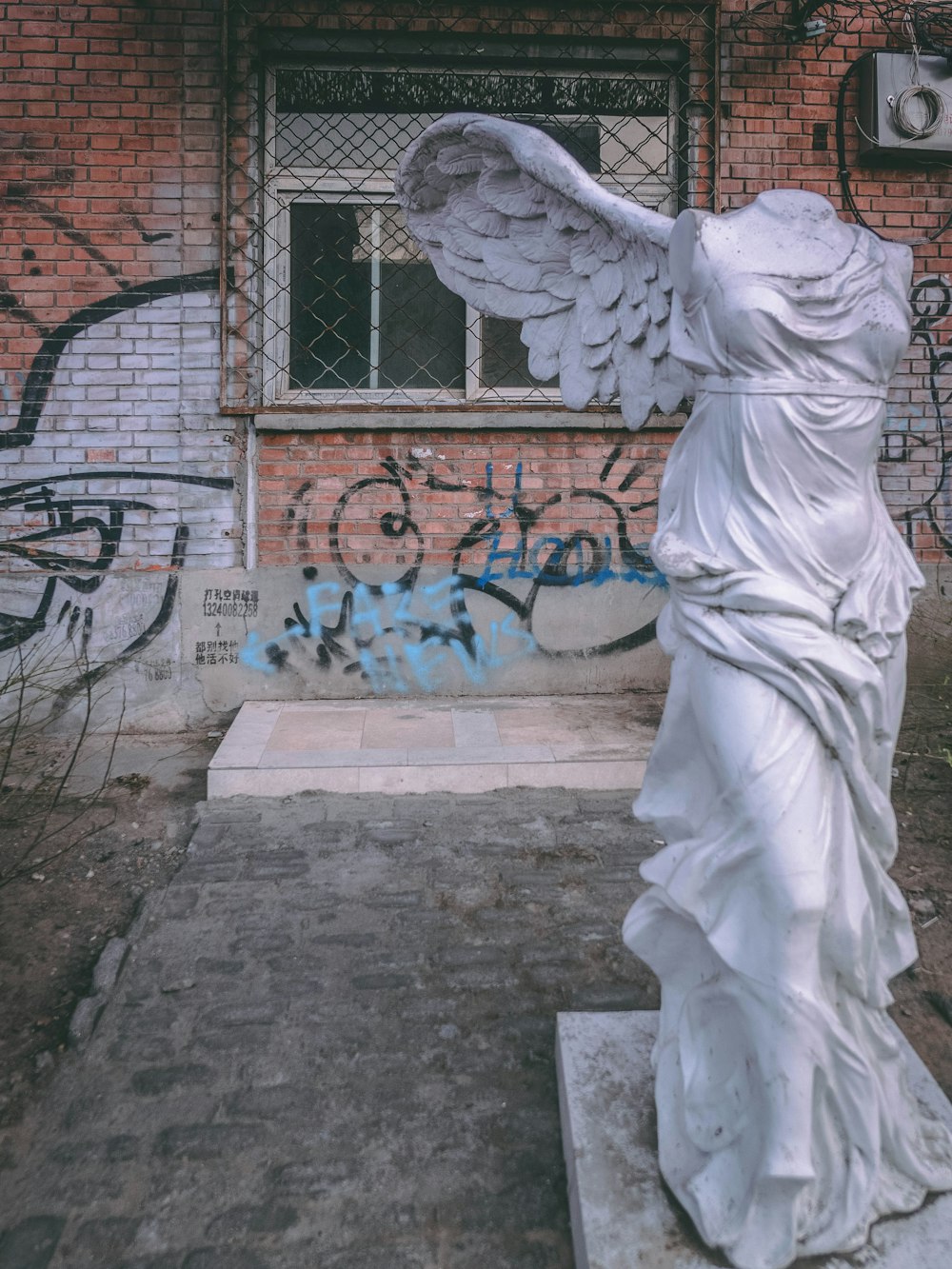 a statue of a woman with wings in front of a building