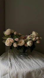 Variety of rose buds in soft pastel shades displayed on a wooden table
