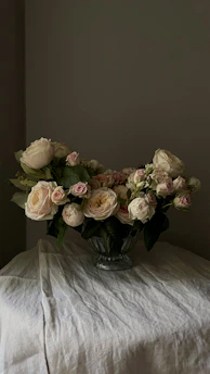 Variety of rose buds in soft pastel shades displayed on a wooden table