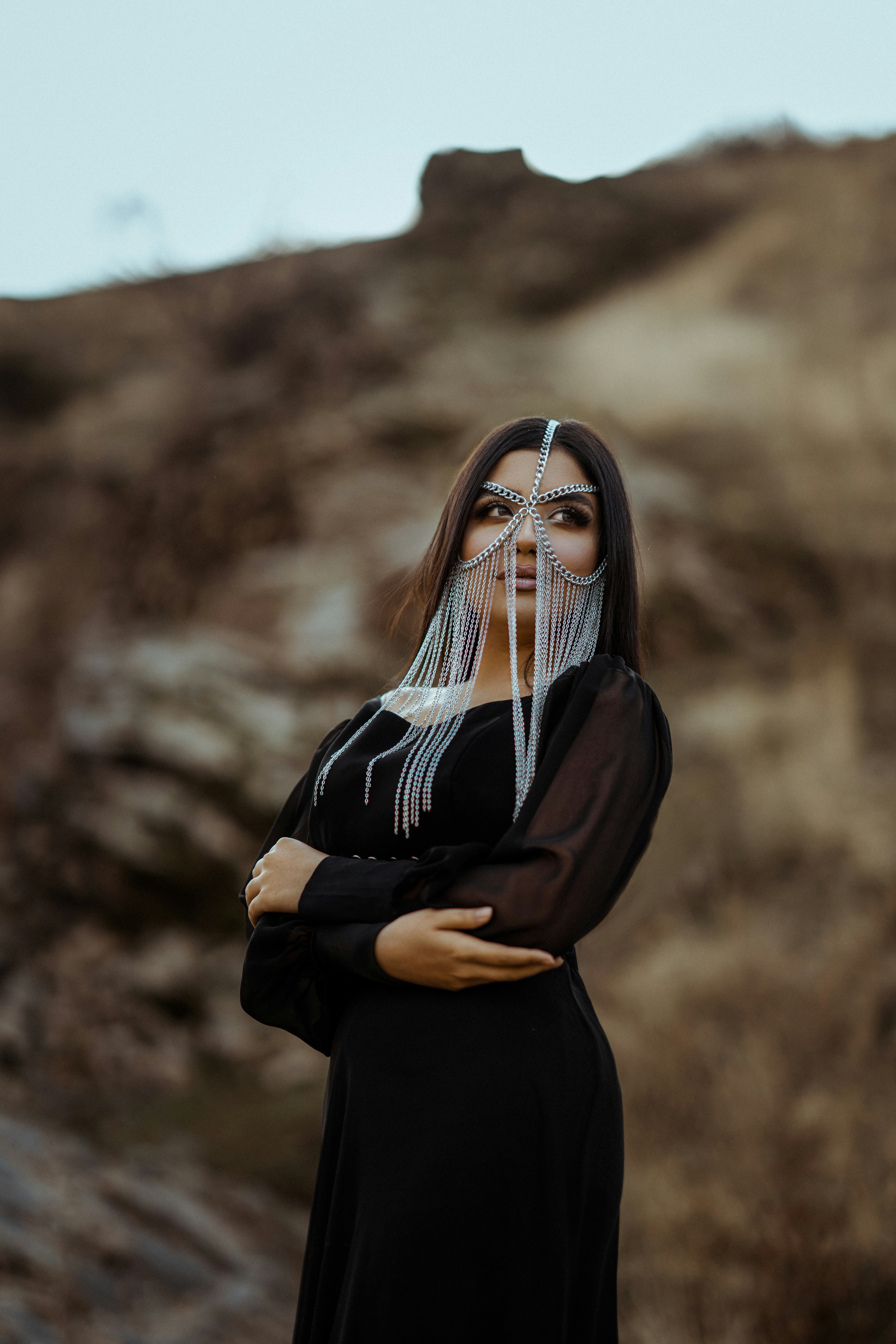 Seorang wanita dengan gaun hitam sedang berpose untuk berfoto
