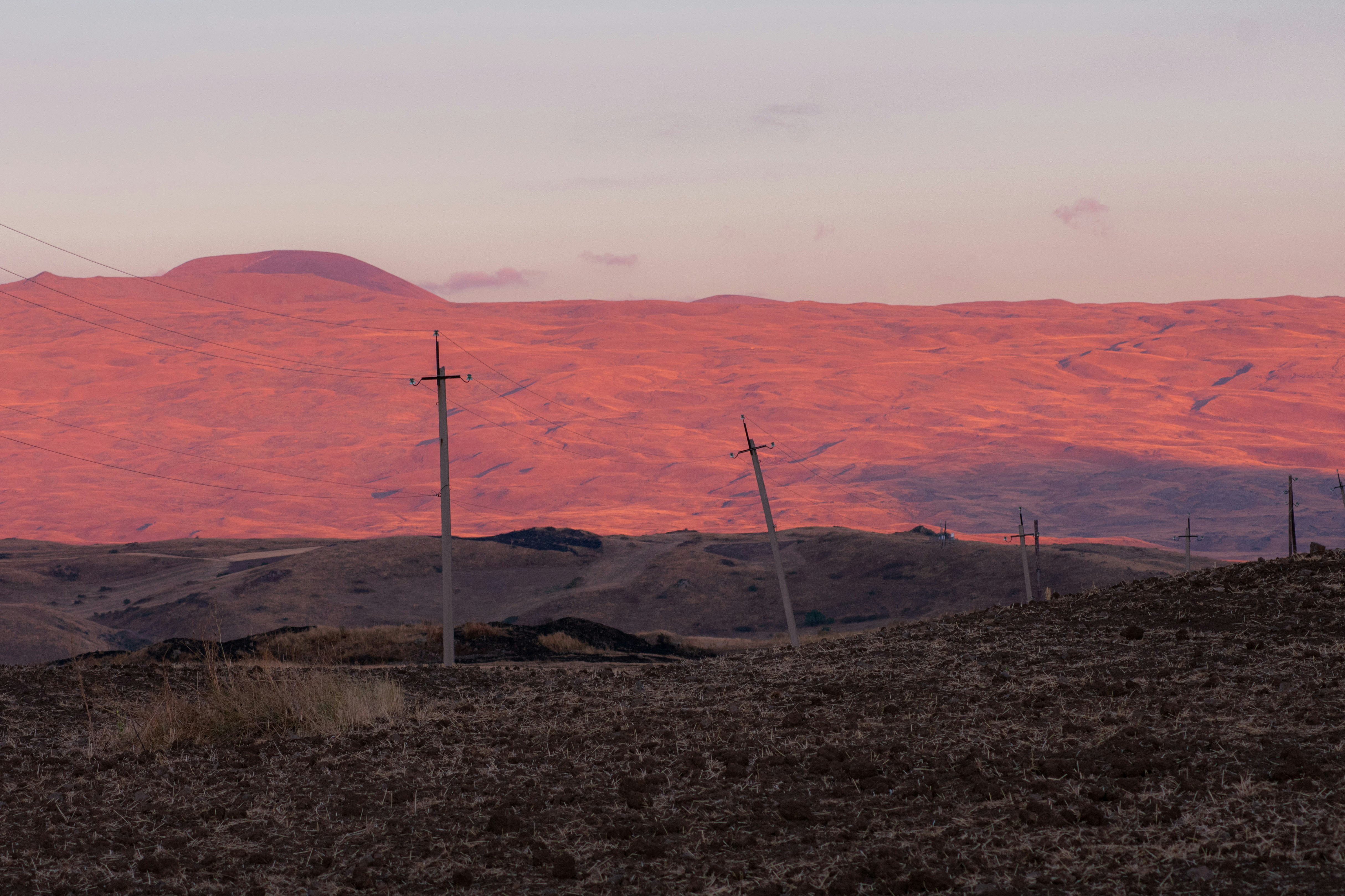 a mountain range with telephone poles in the foreground