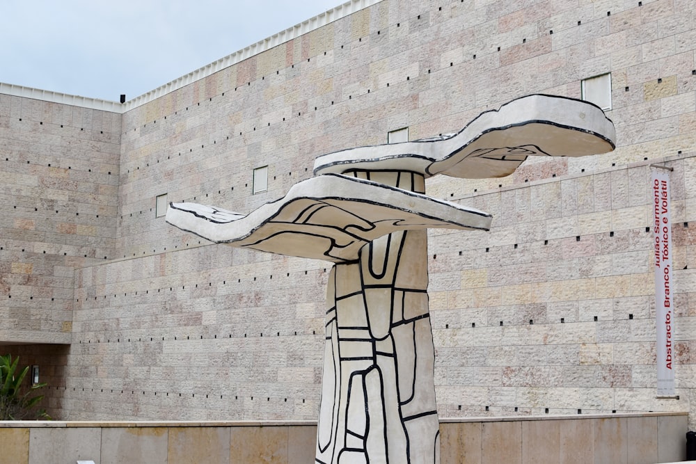 uma escultura na frente de um edifício de tijolos
