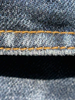 Close-up of a bright coral t-shirt fabric showing durable stitching and rich color