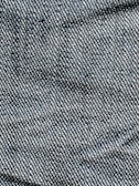A close-up view of denim fabric with visible blue and white threads intersecting to form a classic twill pattern.