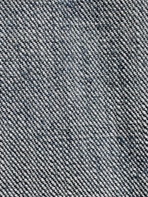 A close-up view of a textured fabric with a woven pattern. The fibers alternate between dark blue and white threads, creating a characteristic denim appearance.