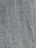 A close-up view of a woven fabric texture featuring a dense pattern of interlaced threads. The fabric appears sturdy and thick, with a prominent diagonal weave pattern, indicative of denim material.